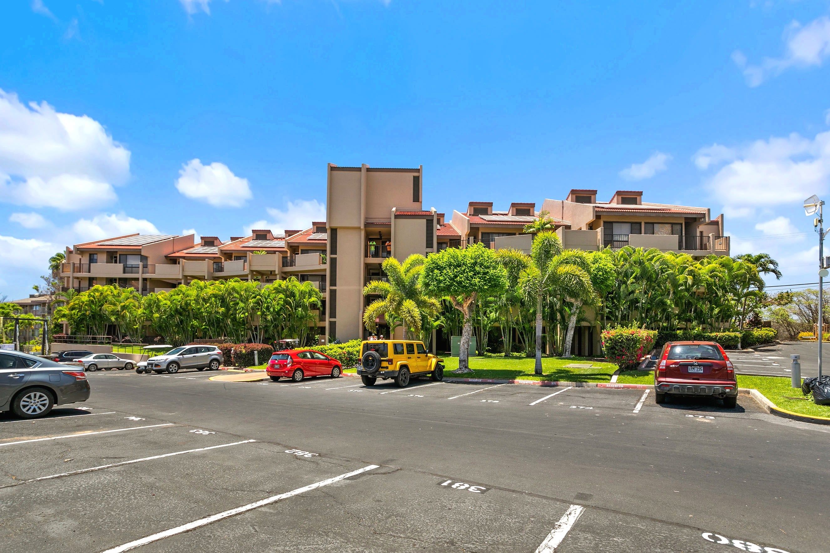 A multi-story hotel with a parking lot in front.
