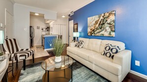 Una sala de estar con un sofá, una mesa de centro y una pared azul decorativa.