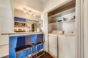 A compact kitchen with a microwave, oven, and a built-in washing machine. - I34 - Apt|Patio|11mi to Convention Ctr|Sleeps 2 (Irving)