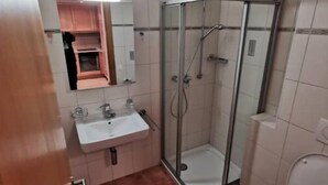 A bathroom with a glass-enclosed shower, a sink, and a toilet. - Superbe Studio Dans L'enceinte des Bains Thermaux de Saillon (Saillon)