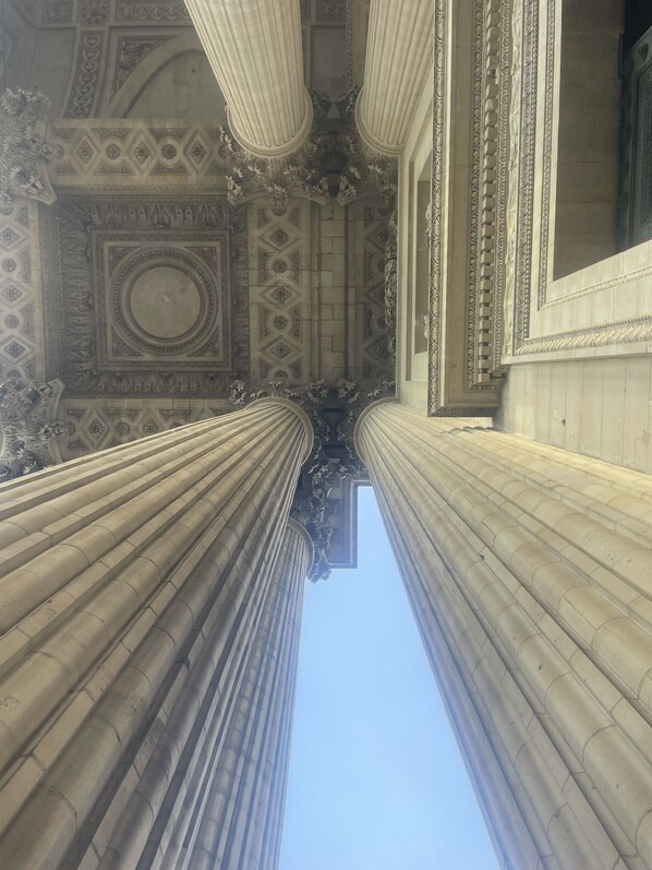 A view of tall, classical columns leading to a grand entrance with detailed ceiling and wall decorations.