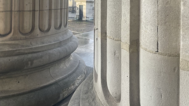 A view through a doorway with large stone columns, a fountain, and a building in the background. - Beautiful place with a beautiful barn and a beautiful garden (Verrières)