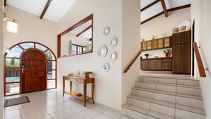 A spacious entryway with a wooden door, a console table, and a staircase leading to upper floors. - ~Sleeps 12 ~Spacious ~Private Pool ~Great Location (Noord)