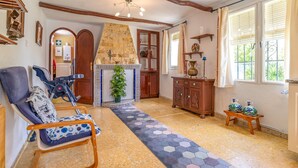 Una sala de estar acogedora con chimenea, un banco de madera y piso de baldosas.