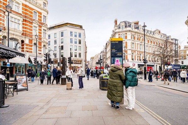 A busy urban street with pedestrians and historic buildings. - Charming flat Leicester Square (London)