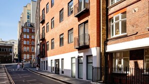 Un edificio de varios pisos con fachada de ladrillo, múltiples ventanas y balcones.