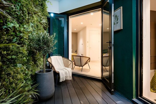 A modern outdoor seating area with a chair and a potted plant. - Tranquil 3 Bedroom a few steps from Covent Garden (Greater London)