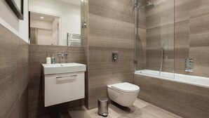 Une salle de bain moderne équipée d’une douche, de toilettes et d’un lavabo.