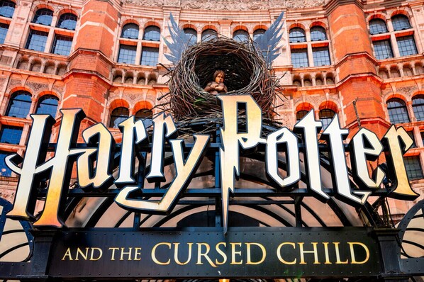A sign with the text "Harry Potter and the Cursed Child" and a nest with a figure inside.