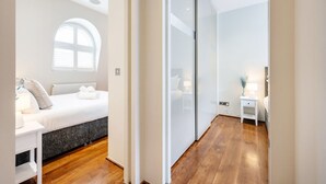 A modern bedroom with a bed, bedside table, lamp, and a large window. - Chic 2 Bedroom in South Kensington (Greater London)