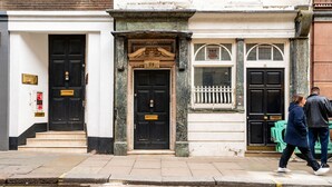 A building with two black doors, a white facade, and a green door with a white fence. - Unique Covent Garden Townhouse! (Greater London)