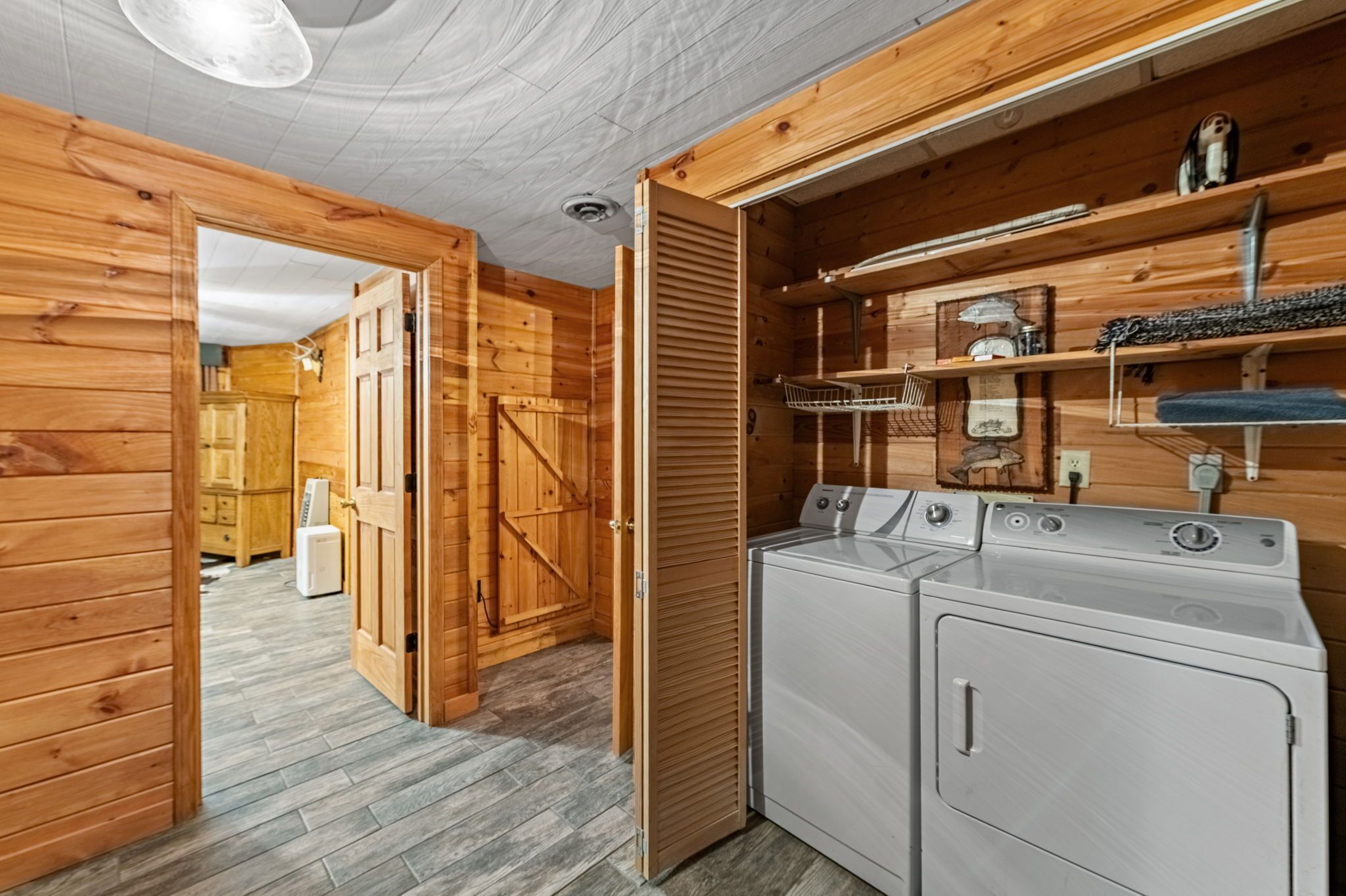 Una lavanderia con pareti in legno e una lavatrice.