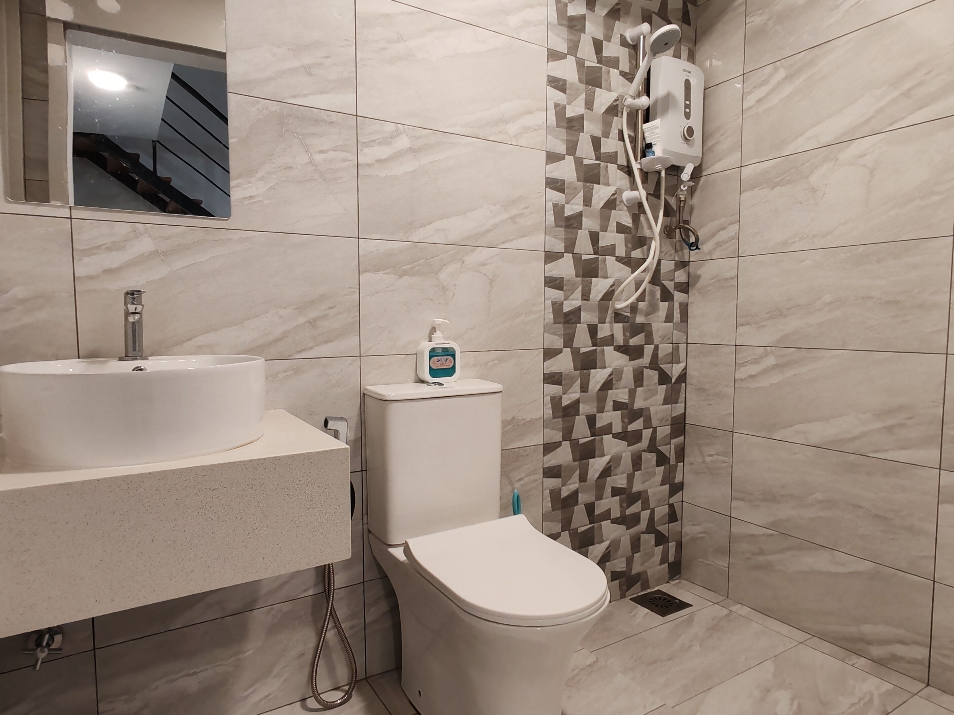 A modern bathroom with a white sink, toilet, and shower.
