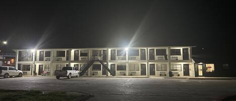 A multi-story building with a central staircase and a parking lot.