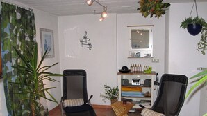 A room with two reclining chairs, a small table, a potted plant, a mirror, and a shelf with various items. - Drei-raum-ferienwohnung Winklmoos, 65qm, Dusche/wc, Extra Bad, Extra Schlafraum, Küche, Balkon (Reit im Winkl)
