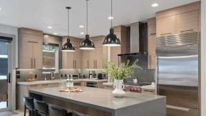 A modern kitchen with a central island, stainless steel appliances, pendant lighting, and a view of the outdoors. - Luxe Park City Ski-In/Ski-Out Retreat (Park City)