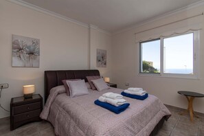 Una camera da letto con un letto, comodini, un tavolo e opere d'arte alle pareti.
