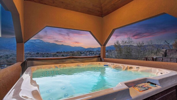 A hot tub with a view of mountains and a sunset. - Highland Heights! Luxe Mountain VIEWS w/ Hot Tub (Colorado Springs)