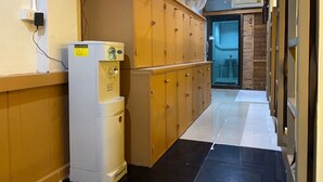 A hallway with a white refrigerator, wooden cabinets, and a tiled floor. - Long Doo Hostel (Ko Phi Phi)