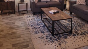 Una sala de estar con sofá, mesa de centro y ventilador de techo.