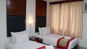 A hotel room with two beds, a nightstand, a wall-mounted lamp, and a window with curtains. - Hotel Seri Putra  (Kuala Lumpur)