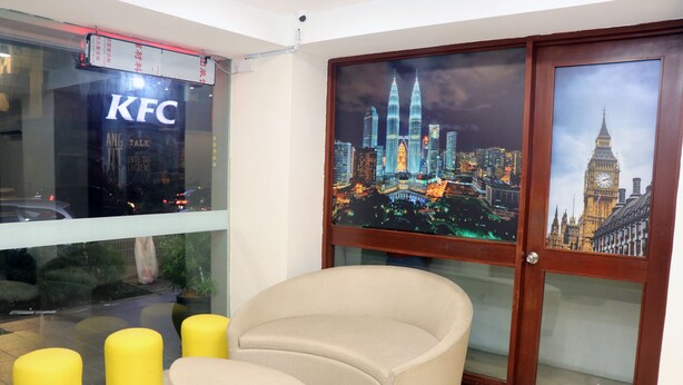 A room with a KFC sign, a chair, and two yellow stools. - Hotel Seri Putra  (Kuala Lumpur)