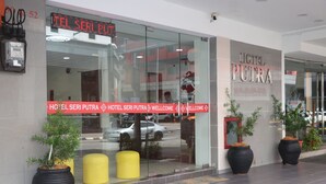 The exterior of Hotel Seri Putra with a glass facade, large potted plants, and a red welcome sign. - Hotel Seri Putra  (Kuala Lumpur)