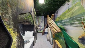 A room with a bed, a mural of a forest scene, and a large dinosaur sculpture. - Vor5334aa: 4 Bed, Volcano Adventure, Pool (Orlando)