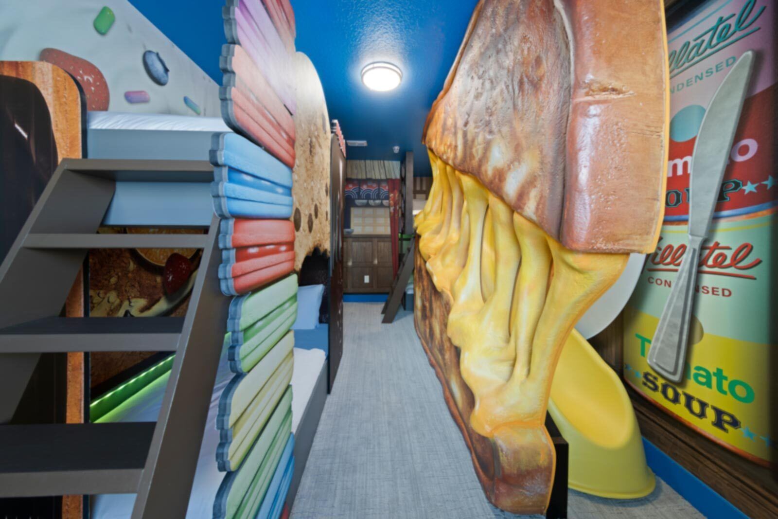 A hallway with a unique art installation featuring oversized objects resembling food items.