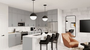 A modern kitchen with grey cabinets, a central island, and black bar stools. - Vor5432aa: 4 Bed, Dragon's Den, Pool (Orlando)