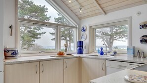 A modern kitchen with large windows, wooden cabinets, and a granite countertop. - "Bosilka" - 75m from the sea by Interhome (Hundested)