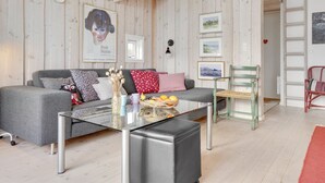 A cozy living room with a grey sofa, a glass coffee table, and a green chair. - "Bosilka" - 75m from the sea by Interhome (Hundested)
