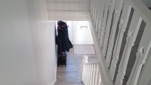 A carpeted staircase with white railings leading to a door.