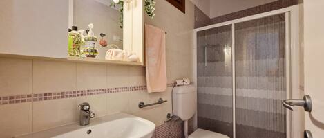 A bathroom with a sink, toilet, and shower.