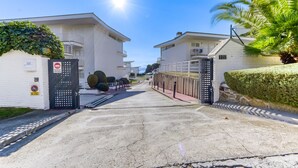 A gated residential area with white buildings, a clear sky, and a sunny day. - RESIDENCIAL ALMADRAVA 2 Roses (Rosas / Roses)