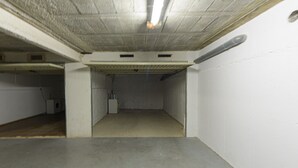 A parking garage with concrete walls, a flat ceiling, and a concrete floor. - RESIDENCIAL ALMADRAVA 2 Roses (Rosas / Roses)