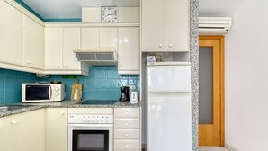 A compact kitchen with a microwave, toaster, and oven. - RESIDENCIAL ALMADRAVA 2 Roses (Rosas / Roses)