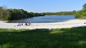 Een strand met mensen die ontspannen en een helder uitzicht op een meer.