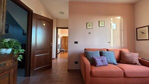 A living room with a sofa, a wooden cabinet, and a staircase.