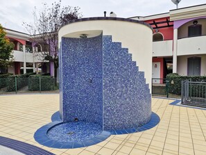 A circular water feature with a mosaic tile design, surrounded by a tiled walkway. - Lovely Holiday Home With Fenced Garden and Pool (San Michele al Tagliamento)