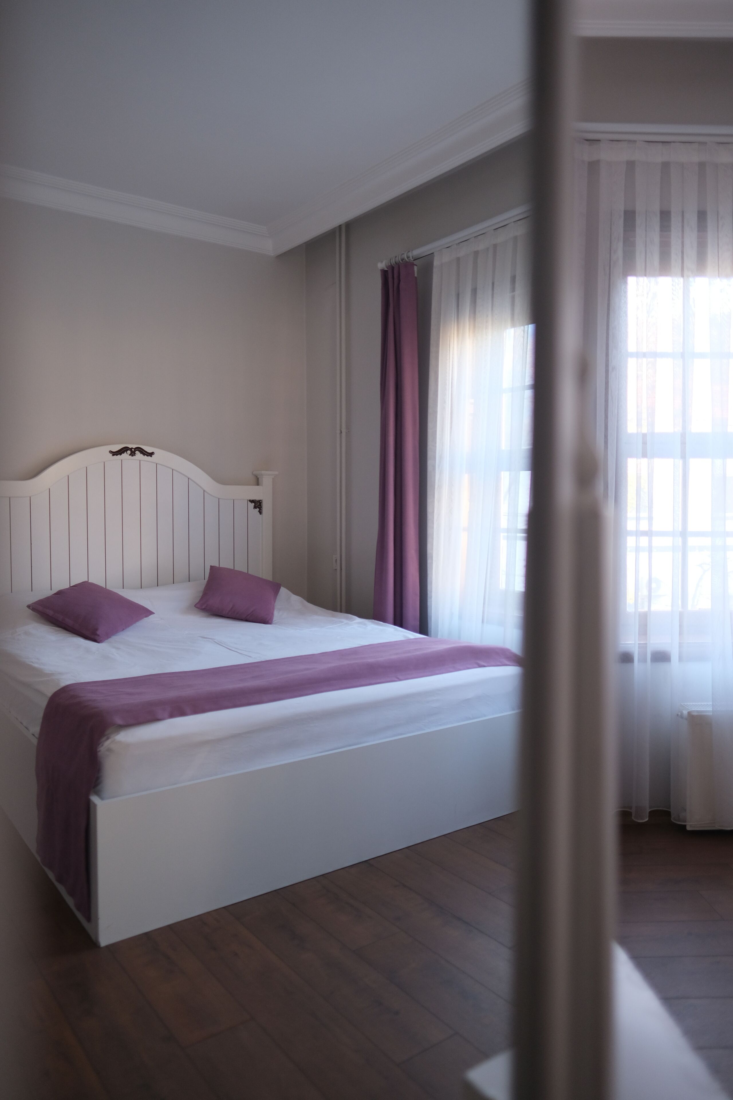 Un dormitorio con cama, cortinas y una ventana.
