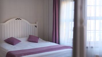 Un dormitorio con cama, cortinas y una ventana.