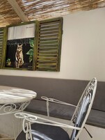 Un comedor con una mesa y sillas, un sofá, y un cuadro de un gato colgado en la pared.