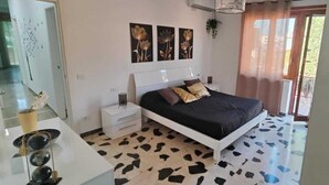 Une chambre à coucher comprenant un lit, une table de chevet, un miroir et une plante décorative.
