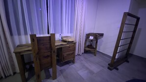 A room with a wooden desk, a chair, a small table with a telephone, and a ladder against the wall.