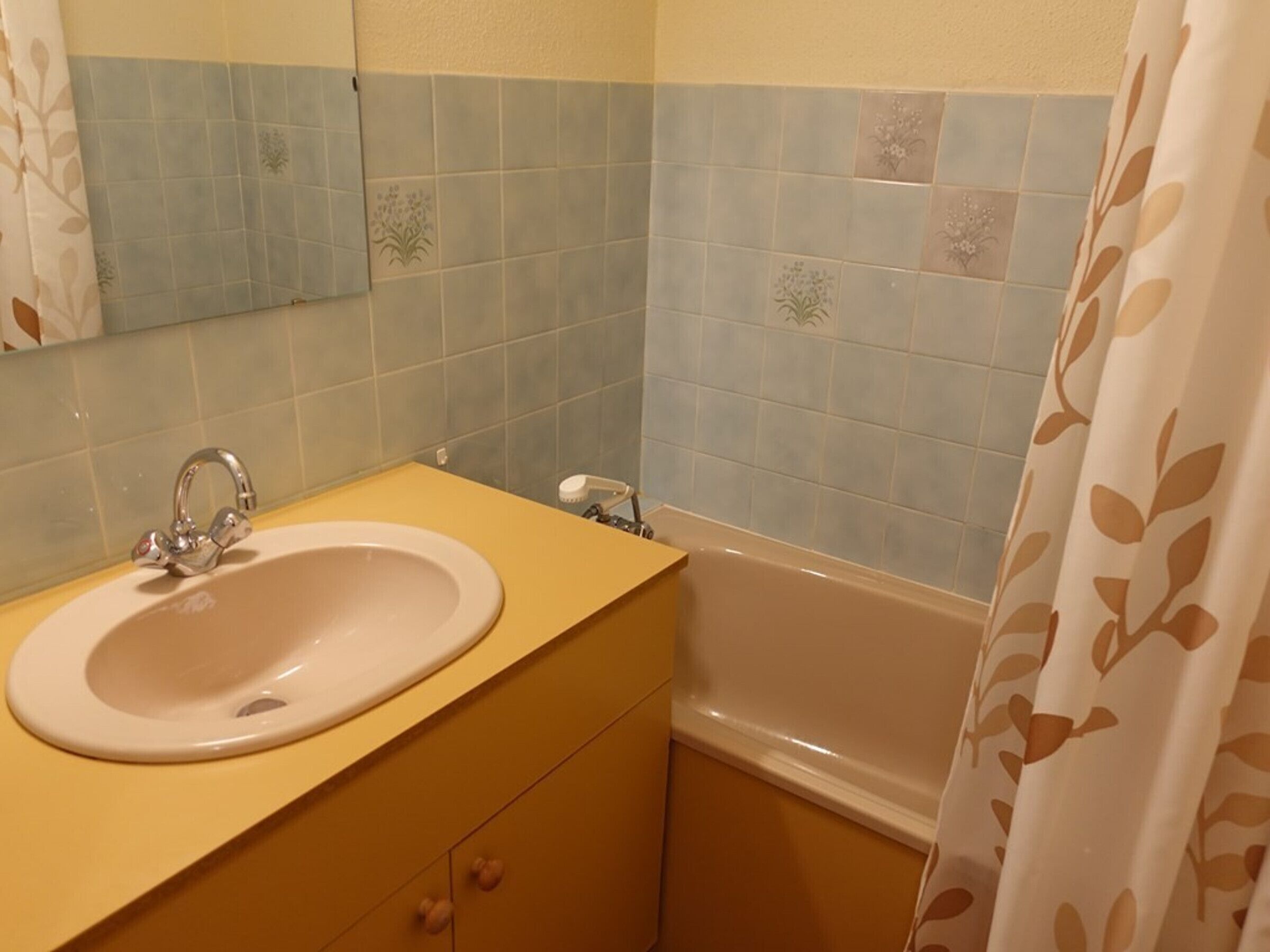 Un baño con lavamanos, espejo y bañera.