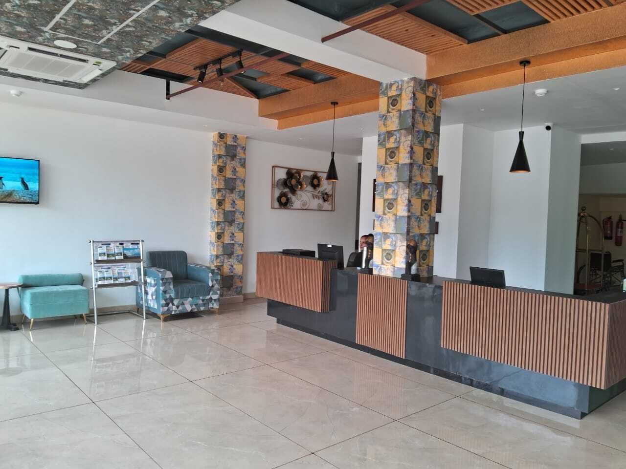 A reception area with a modern design, featuring a reception desk, seating area, and a large wall mural.