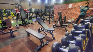A gym with various exercise equipment, including benches, dumbbells, and weight machines. - Hotel Nissar (Srinagar)