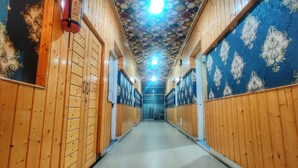 A hallway with wooden walls and a patterned ceiling. - Hotel Nissar (Srinagar)