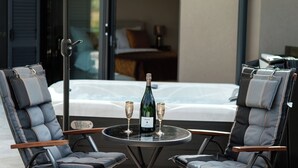 A room with a bed, a table with two glasses and a bottle, and two chairs. - Olive Garden Paradise with Swimming pool (Rovinj)